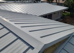 Close-up view of gray metal roofing panels on a residential building, showing clean lines and seams under daylight.